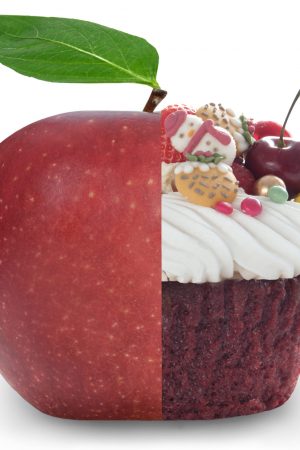 Healthy apple and unheatlhy christmas cupcake merged into one over a white background
